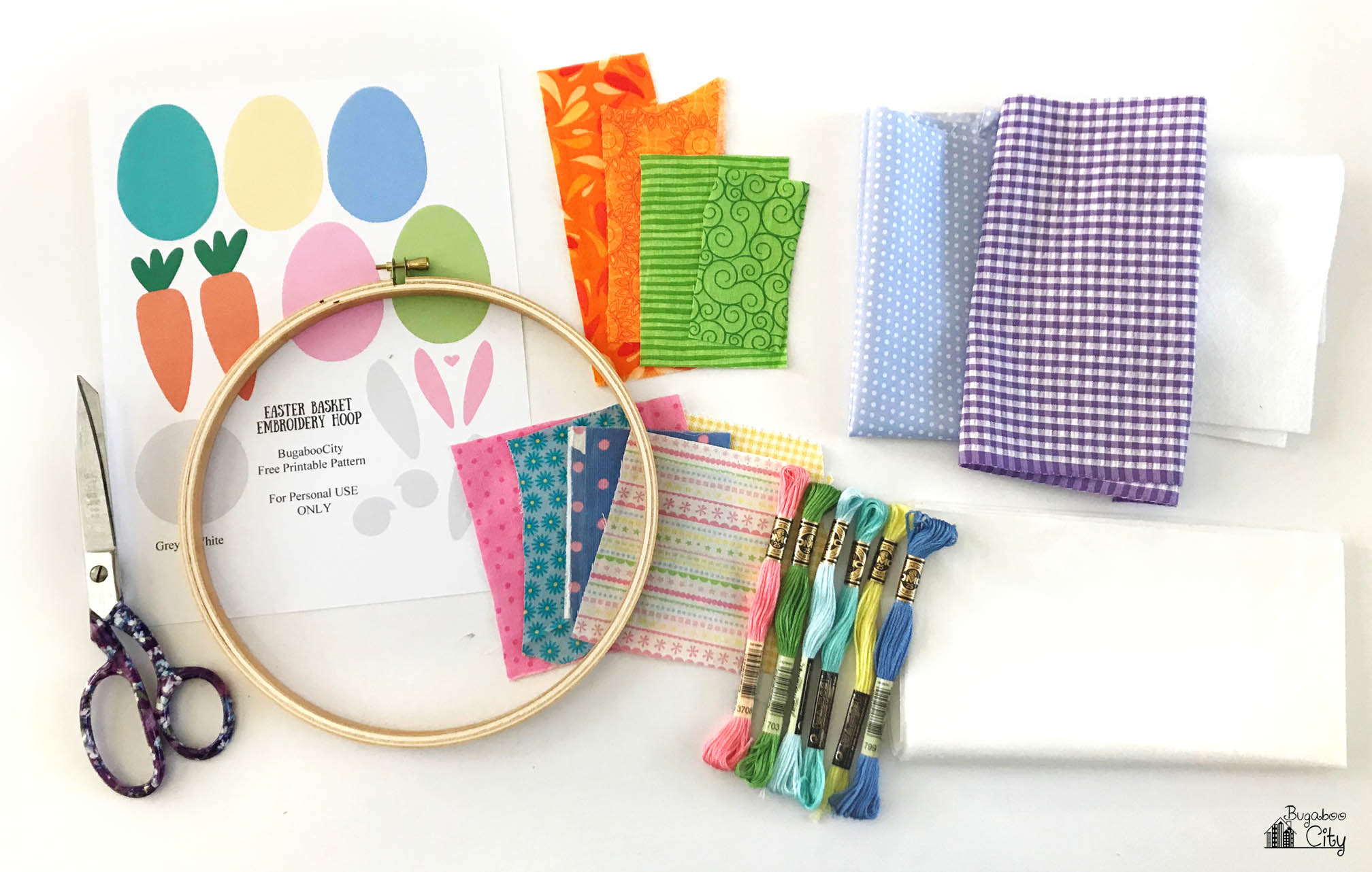 Embroidery hoop, fabric, pattern, embroidery floss, and scissors.
