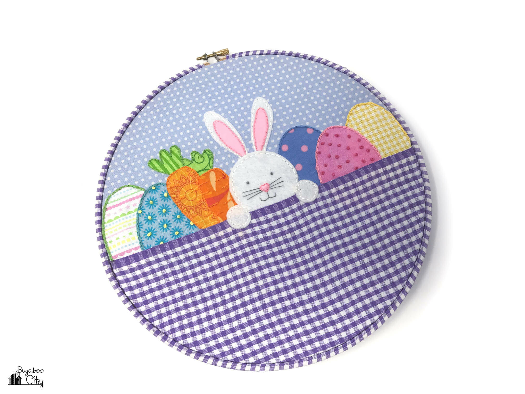 Easter embroidery hoop with a gingham fabric basket and a bunny and eggs appliquéd inside.
