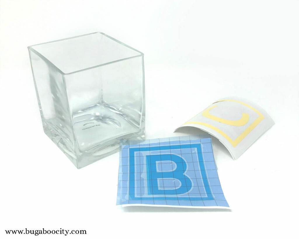 Clear square vase with letter vinyl cut outs.
