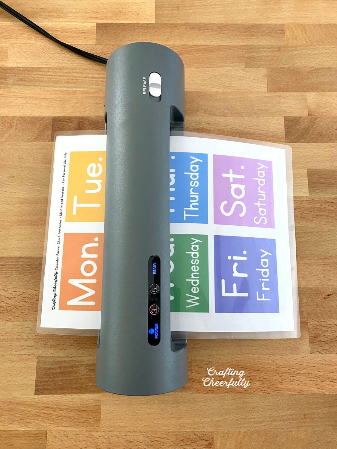 Pocket chart printable being laminate in a thermal laminator.