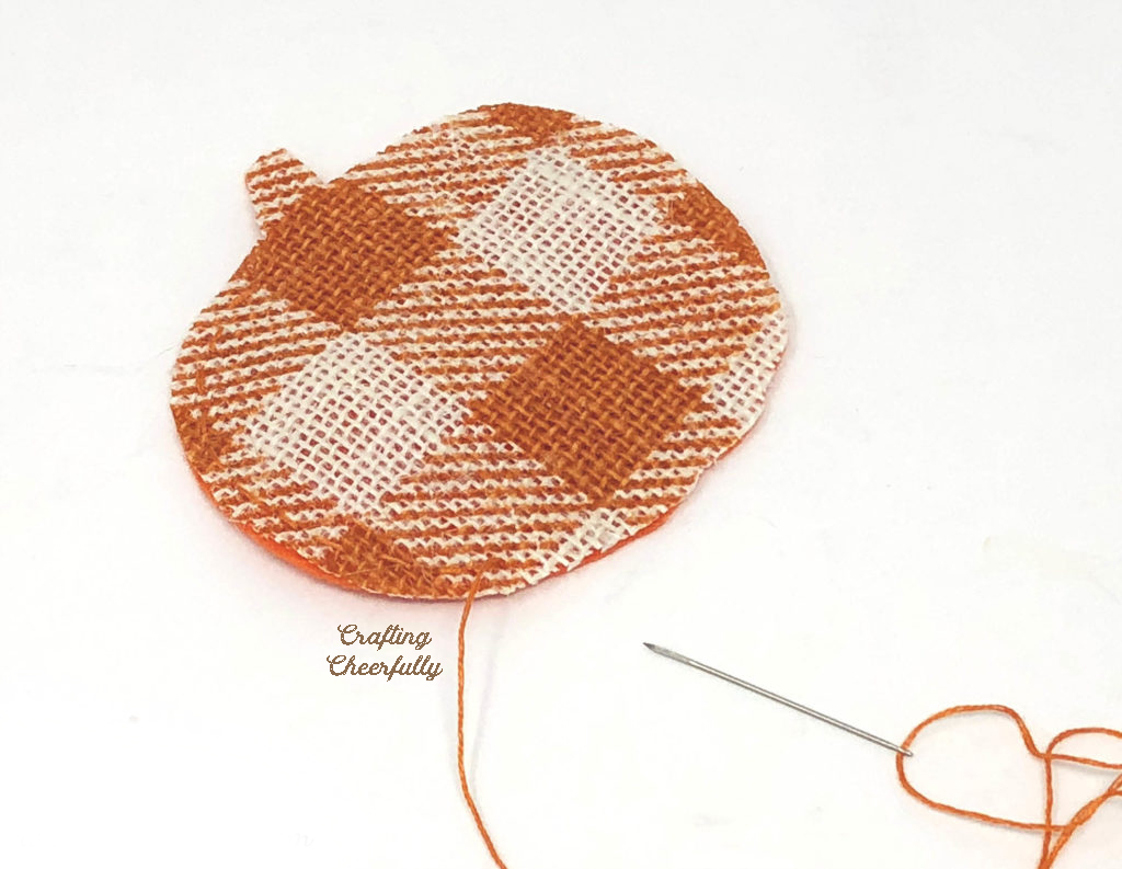 The pumpkin pennant is stitched together with orange embroidery floss.