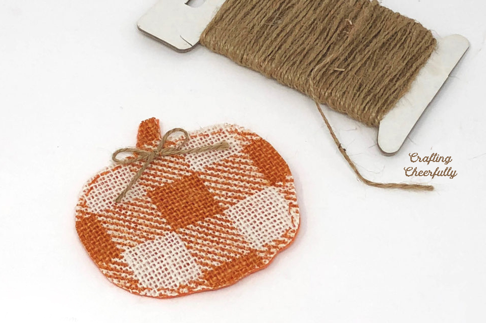 A bow made from twine is added to the top of each pumpkin pennant.