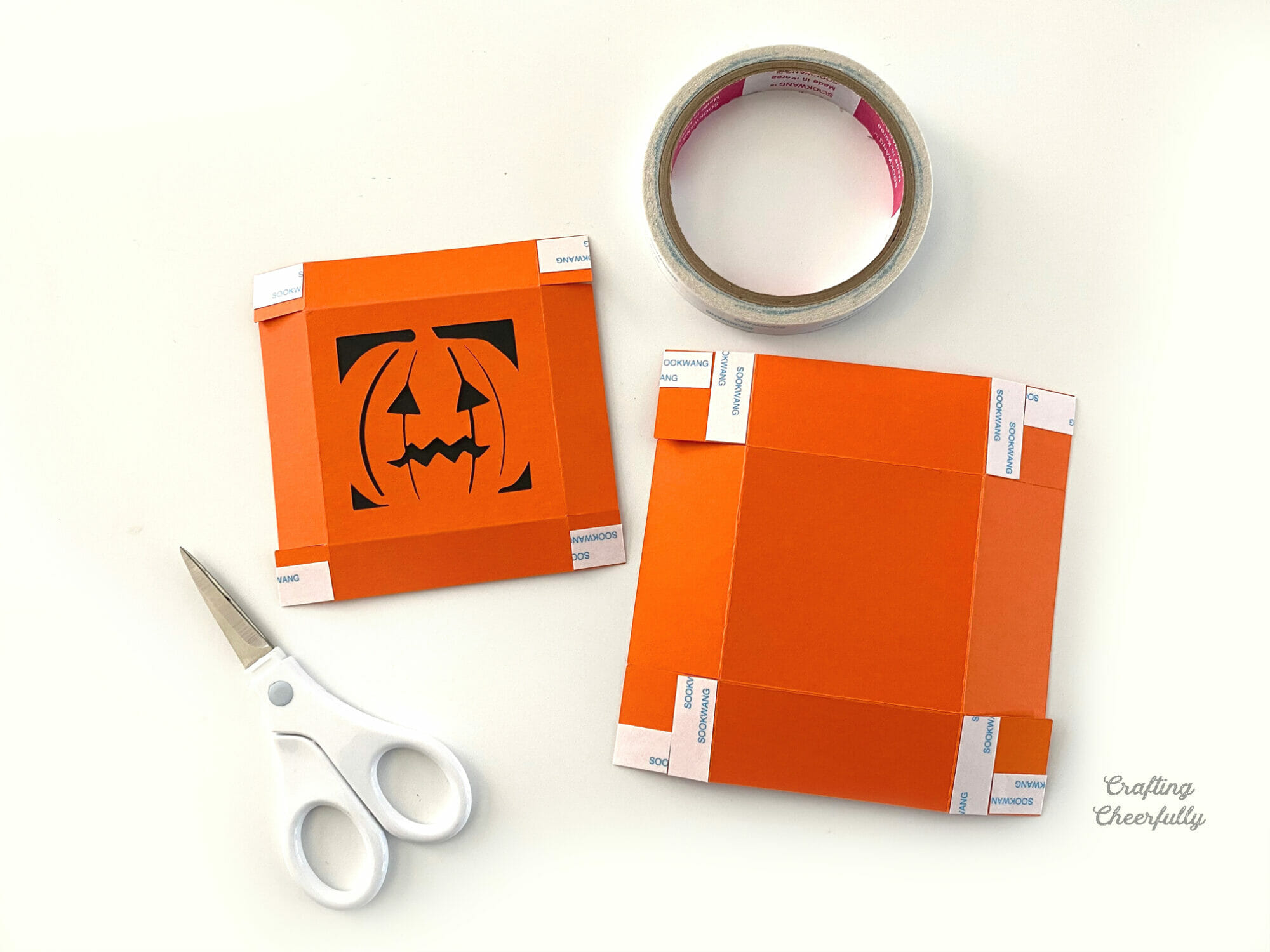 DIY Pumpkin treat box made from orange and black construction paper.