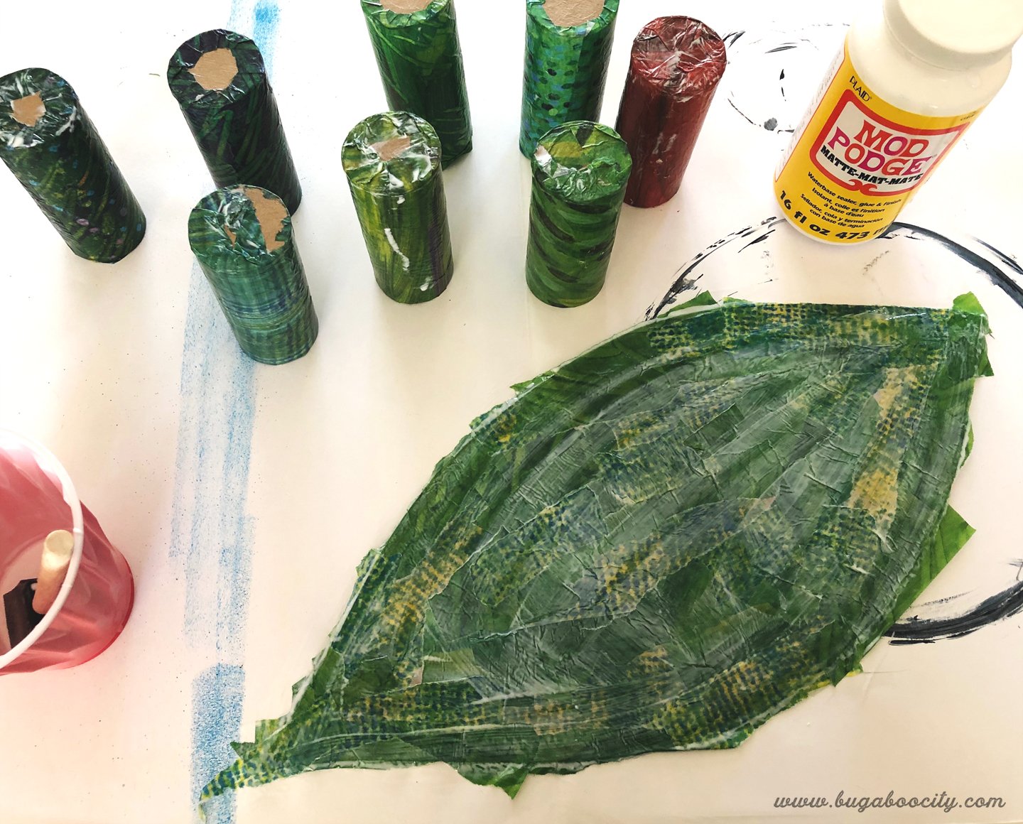 Cardboard leaf is covered in patterned tissue paper.