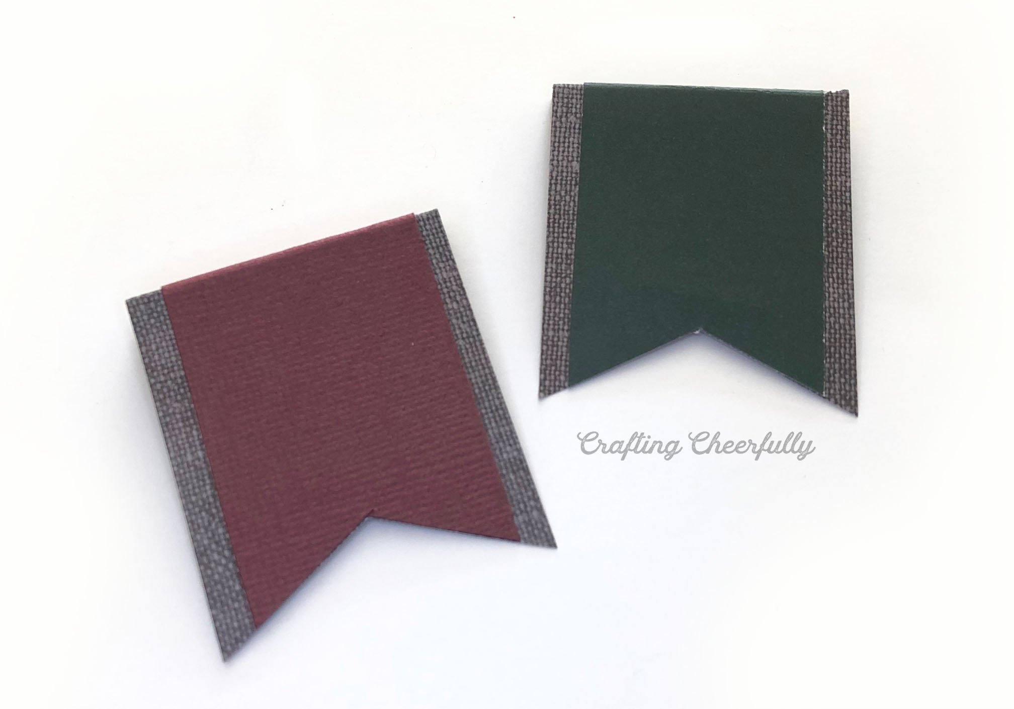 Two banners made with gray paper and burgundy and green paper on top.