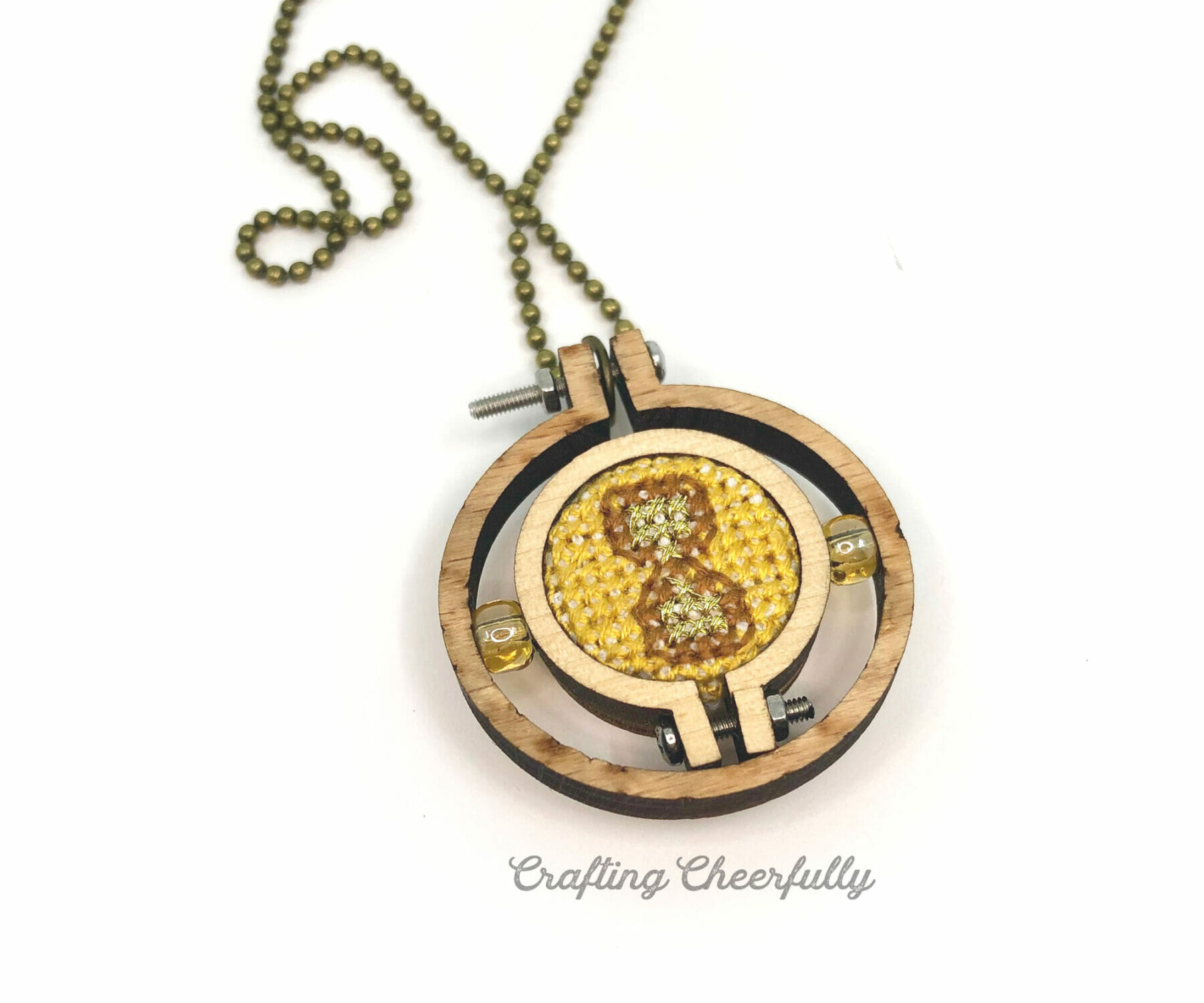 The small hoop with the cross stitched time turner is glued inside the wooden hoop necklace.