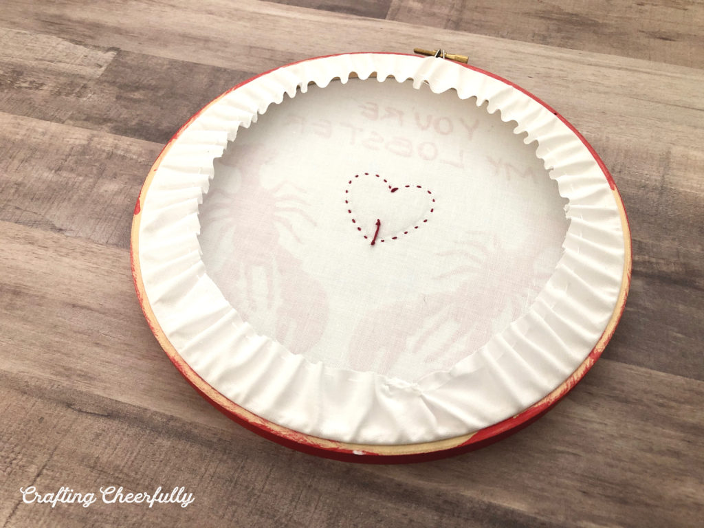 The cotton fabric is gathered to the back of the embroidery hoop.