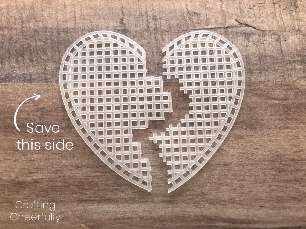 Plastic heart-shaped canvas cut in half, an arrow with the words Save This Side point to the left side which has finished edges.