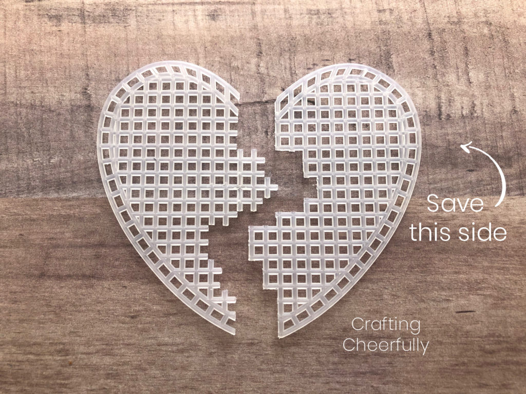 Another plastic heart-shaped canvas cut in half, an arrow with the words Save This Side point to the right side which has finished edges.