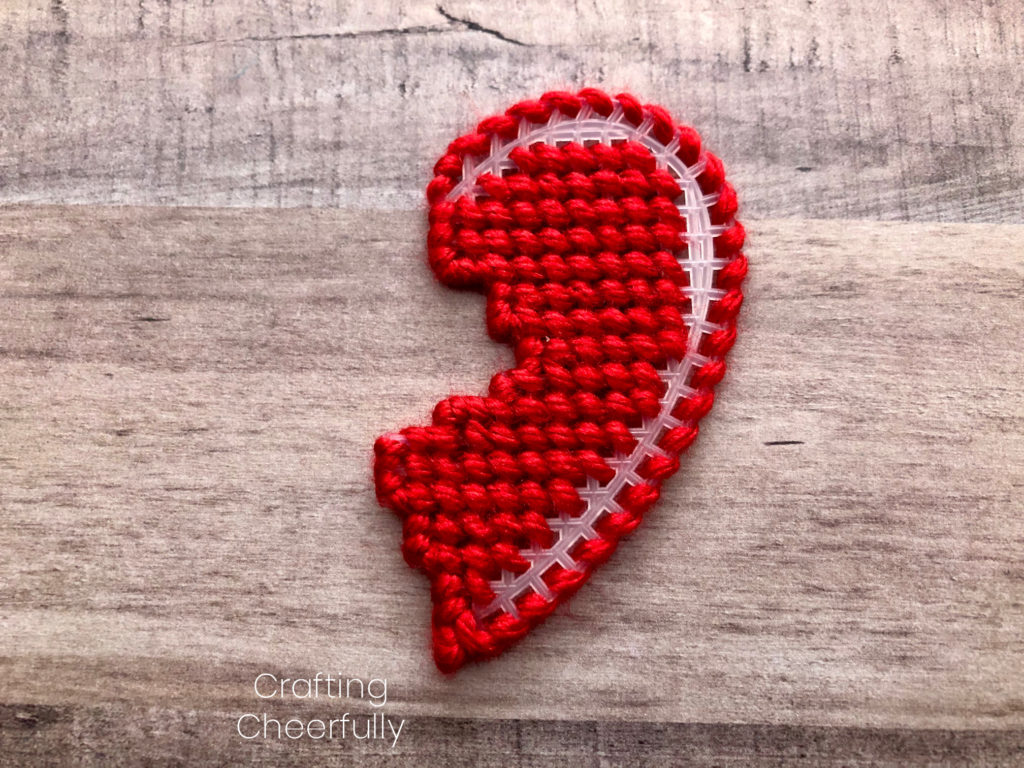 The right side of the heart filled in with red yarn stitches; the edges are covered in red yarn.
