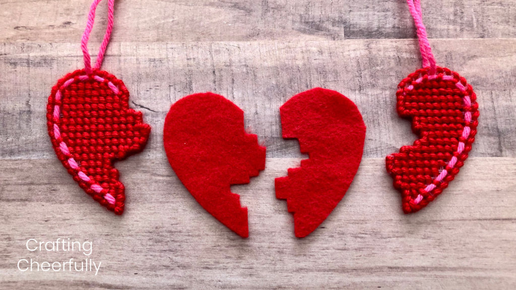 Two pieces of red felt cut to match the pieces of heart necklace; they lay in a row showing how they match.