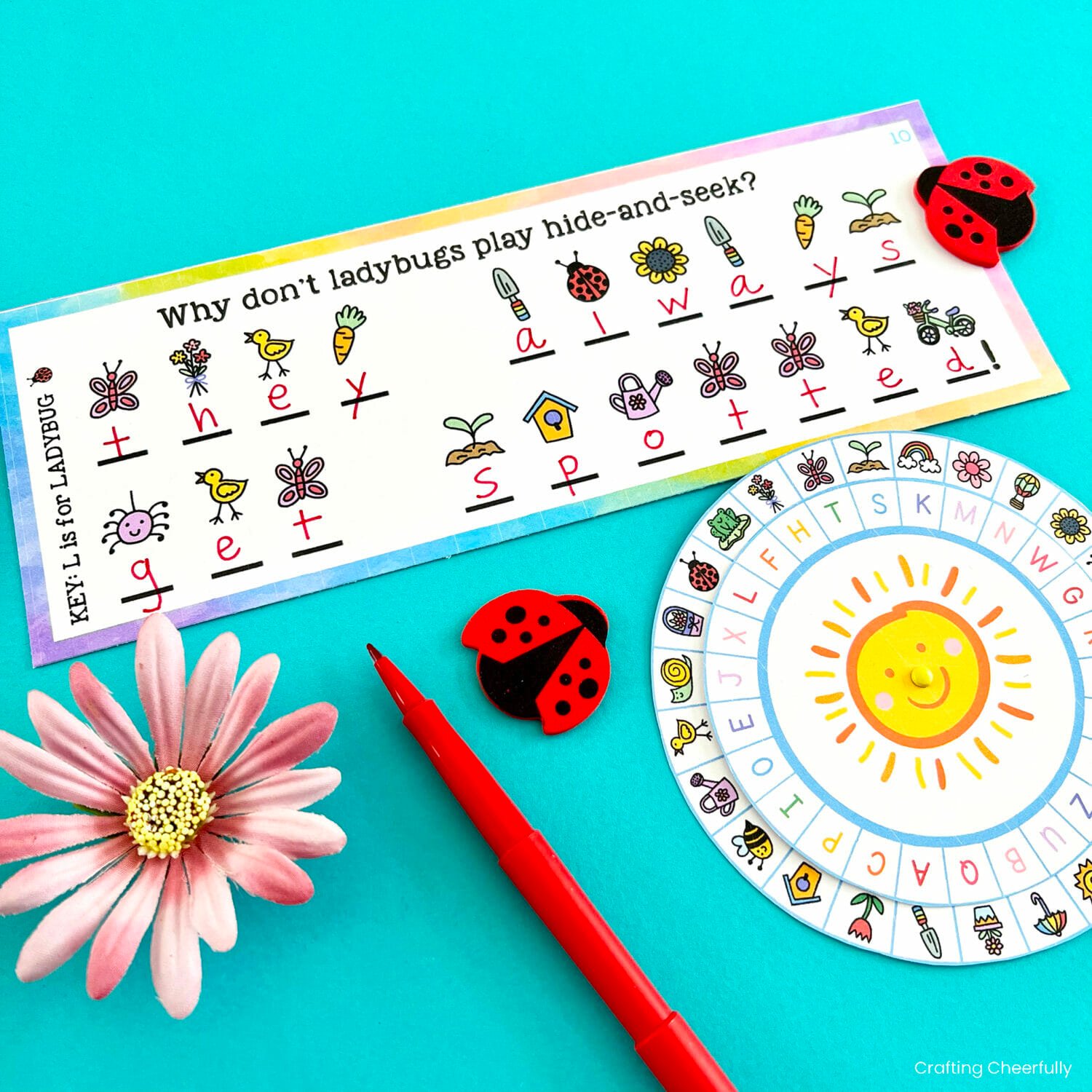 A riddles about ladybugs lays next to a flower, decoder wheel, red pen and foam ladybugs.