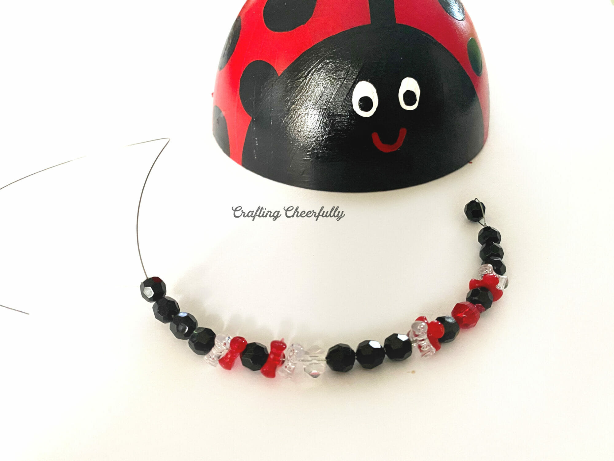 A finished beaded leg with black, red and white beads for the red ladybug.