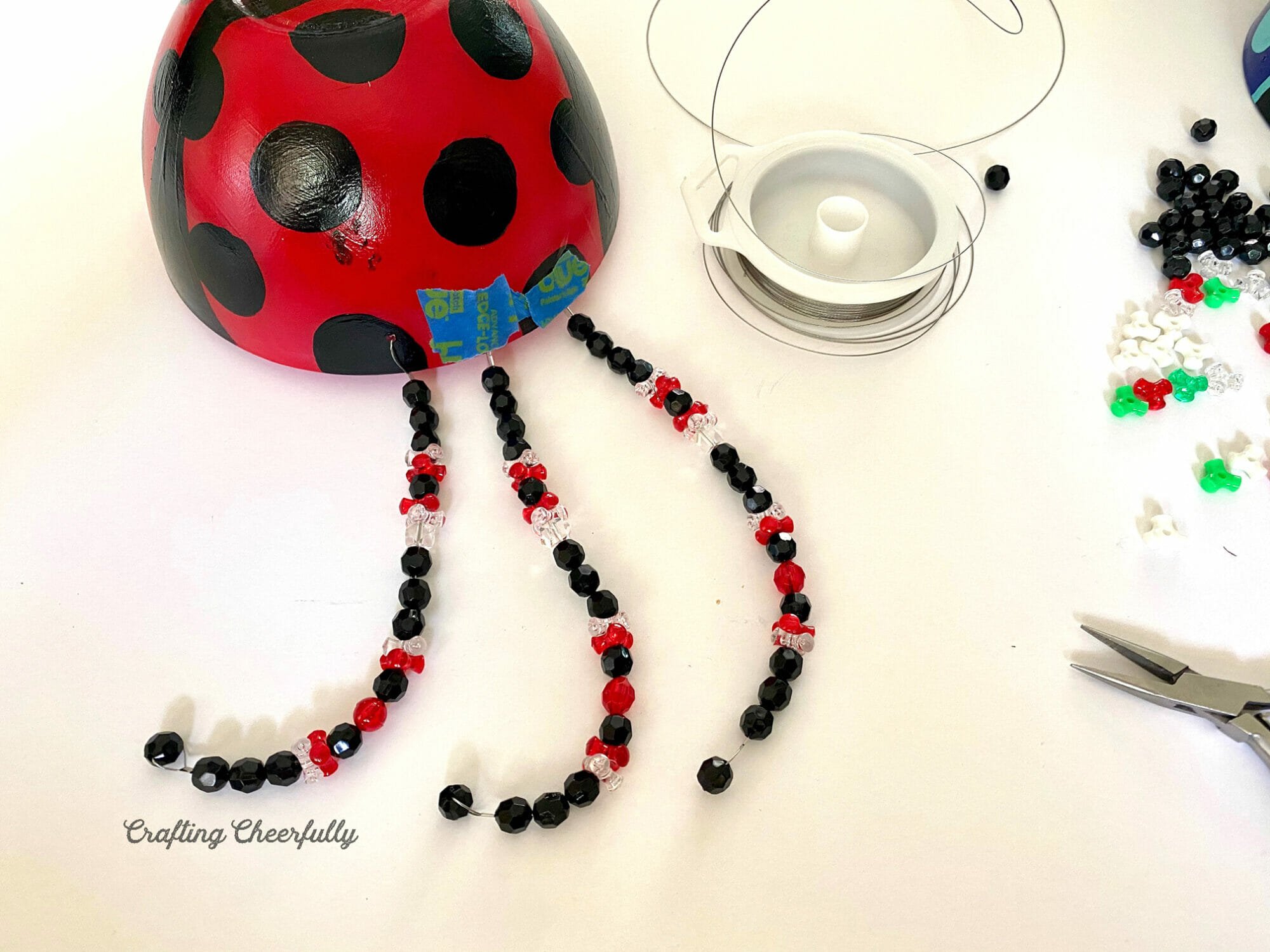 Three beaded legs are added to the side of the ladybug bowl.