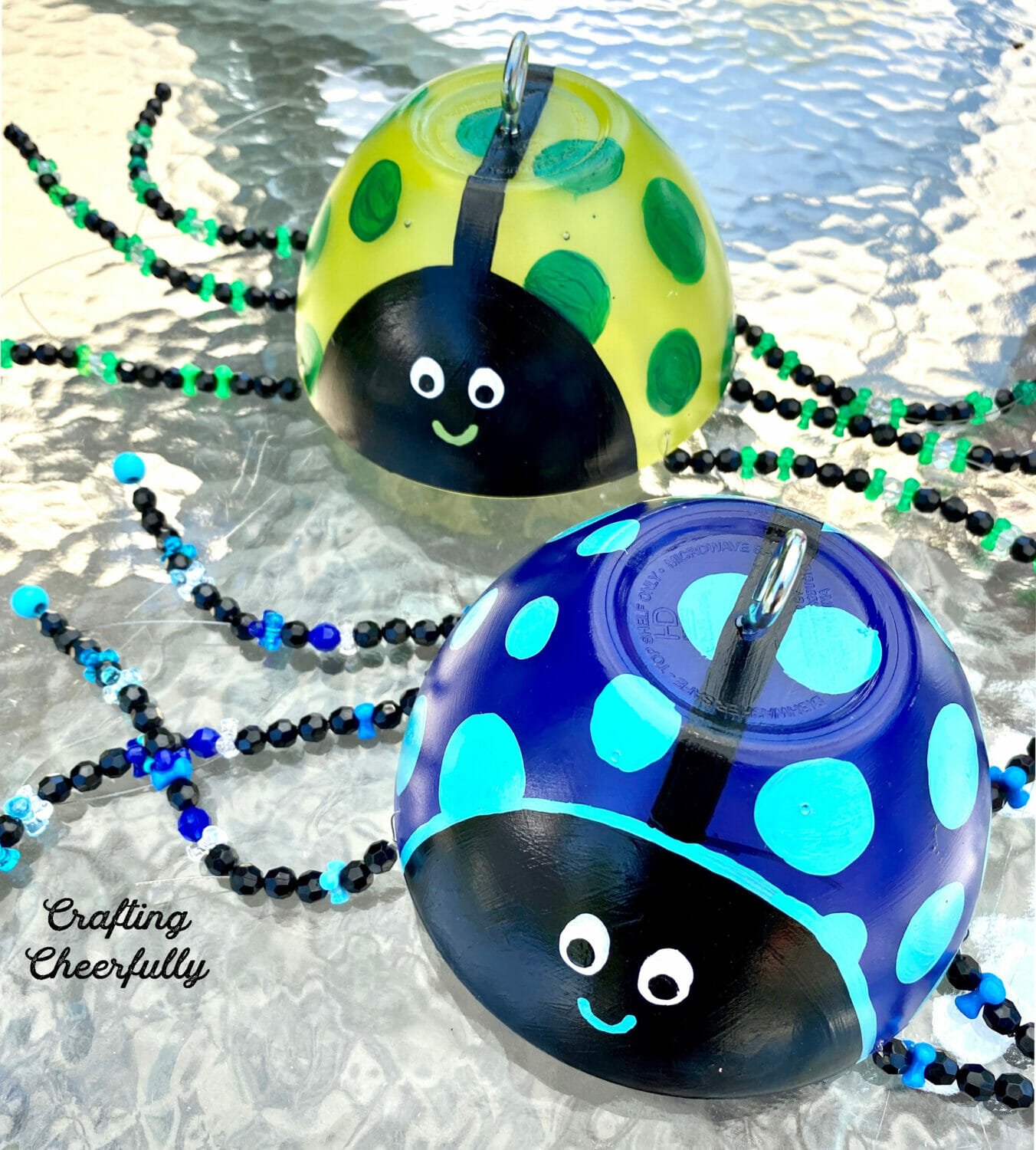 Two cute ladybug garden ornaments, one blue and the other green.