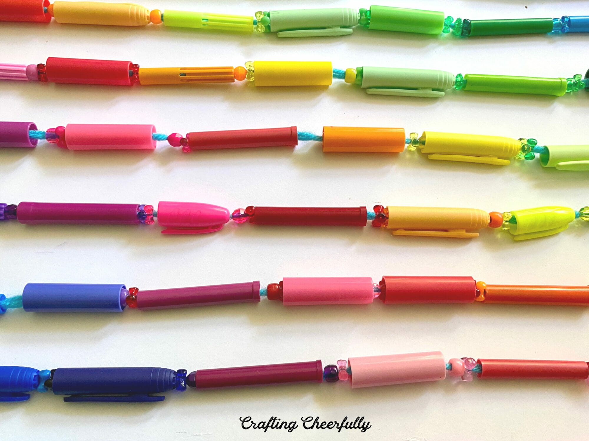 Stands of yarn covered in colorful marker caps and sparkly beads.