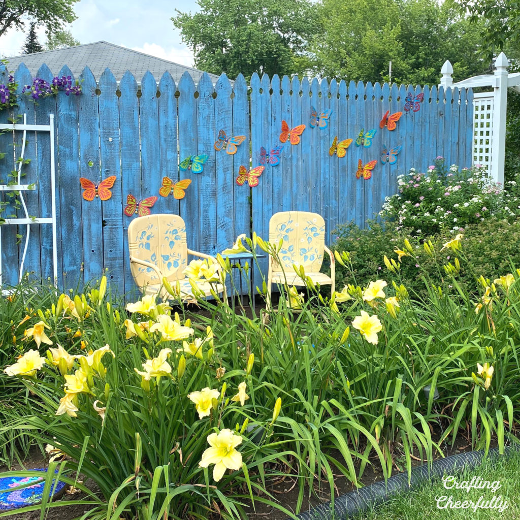 Butterflies on a blue wooden fence in a backyard garden. 