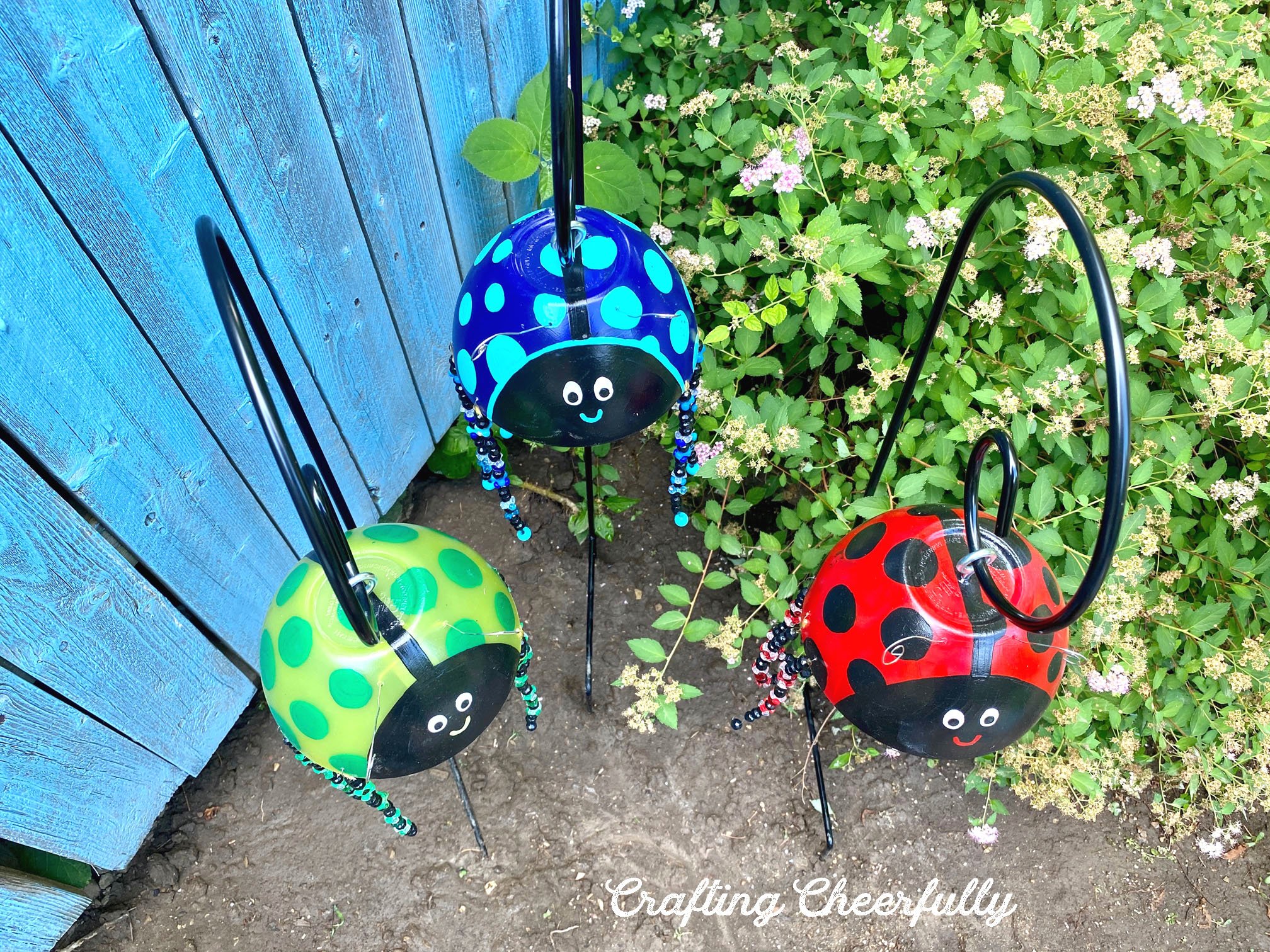 Three ladybug garden ornaments made from plastic bowls.