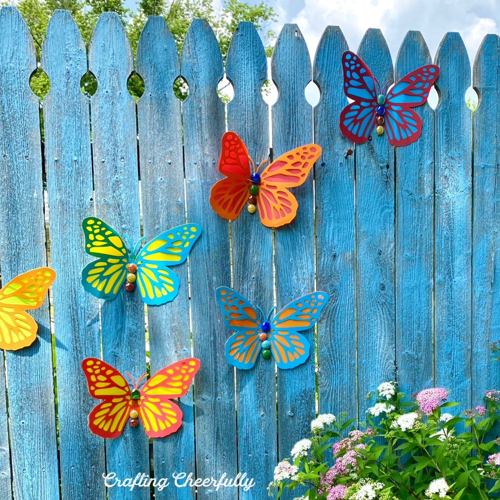 Butterflies on a fence with a couple gemstones missing.