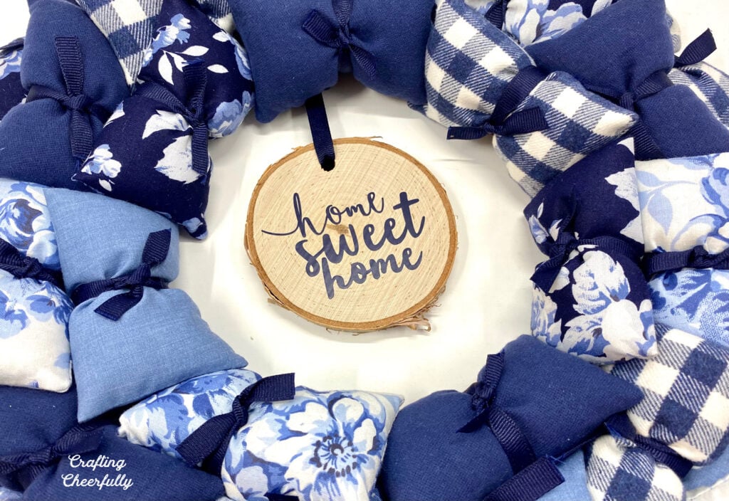 Home Sweet Home Pillow wreath with wood slice in the center that reads Home Sweet Home.