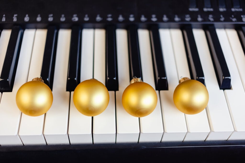 Piano with gold ornaments resting on the keys.