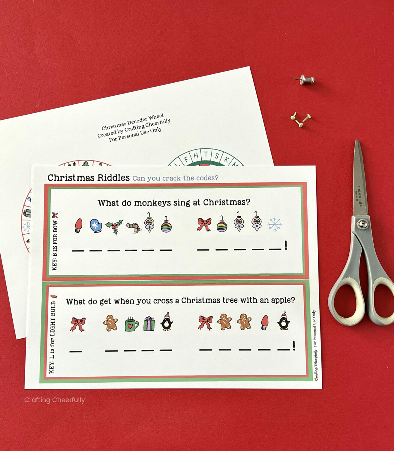 Printable sheets lay next to tiny brads, a pushpin and a scissors.
