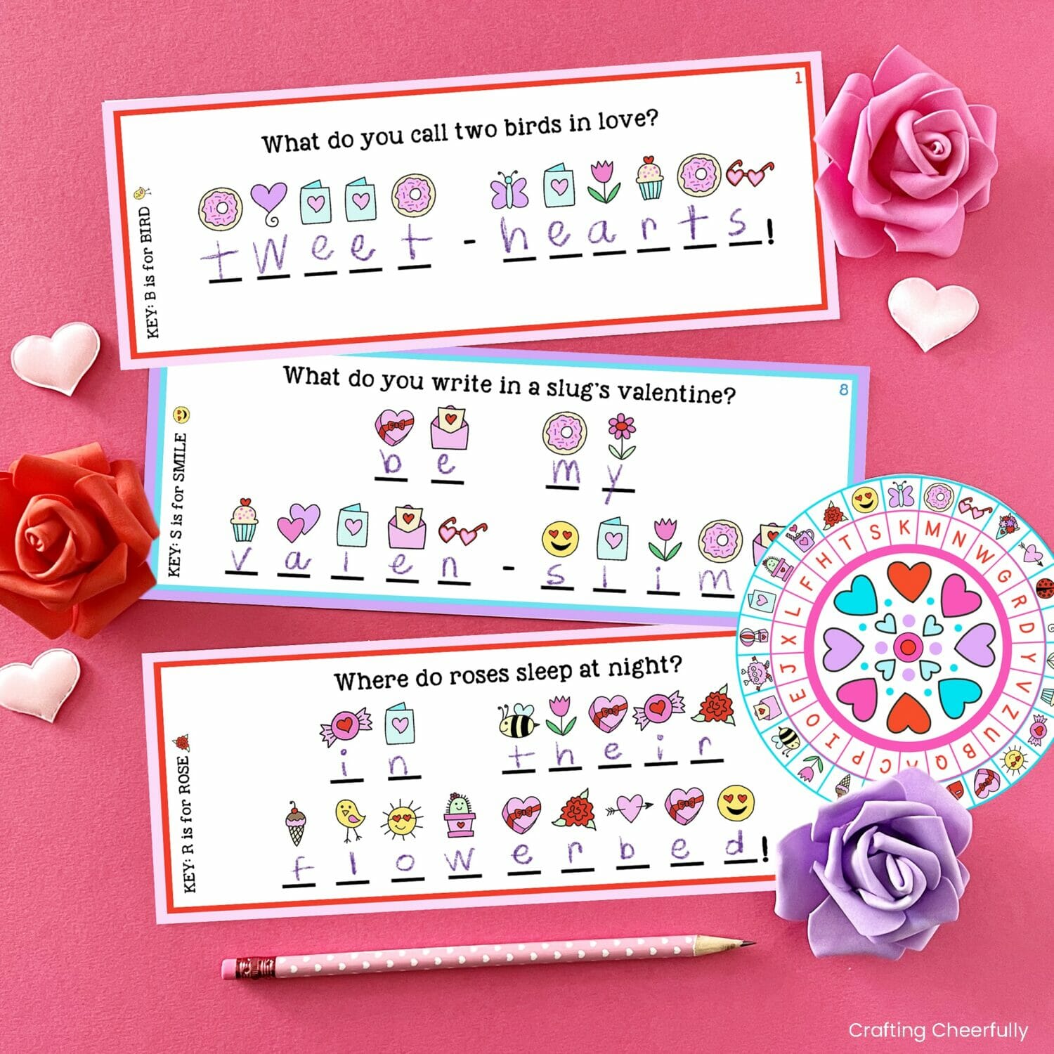 Three riddles written in code lay next to a Valentine's Day decoder wheel.
