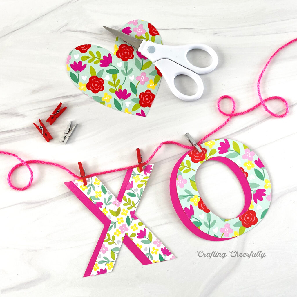 Valentine's Day banner with XO letters clipped to a pink string with mini clothespins.