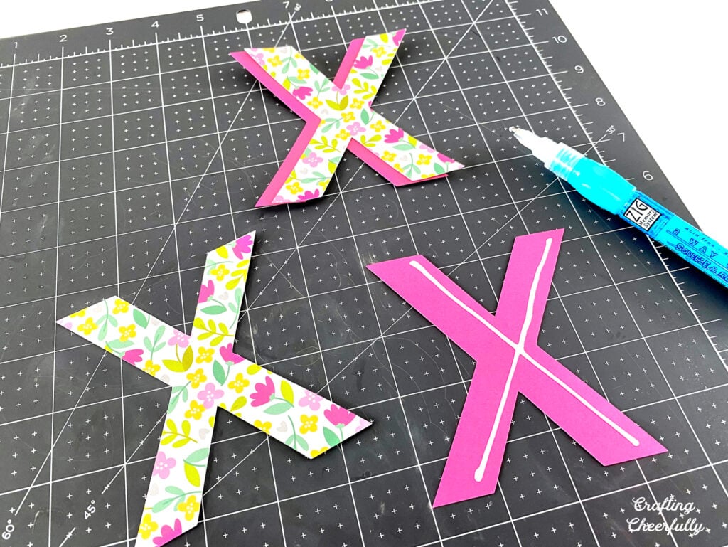 Glue is applied to the X letters so they can be layered.