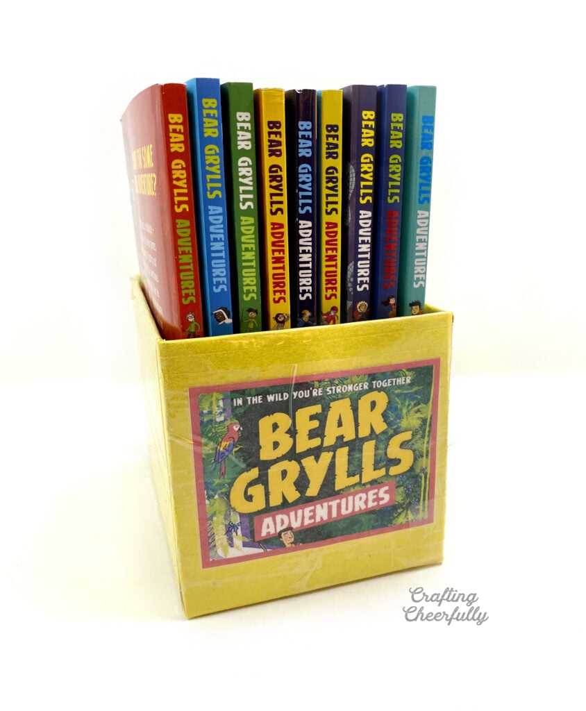 A yellow book bin filled with "Bear Grylls" books.
