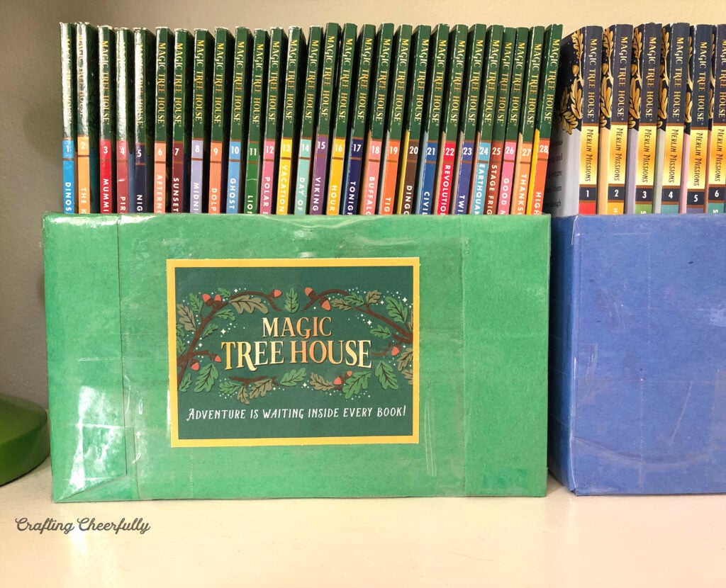 Colorful DIY book bins holding chapter books sit on a dresser. 