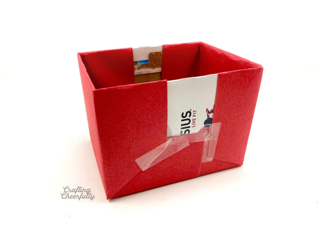Red paper covers both ends of the cardboard box.