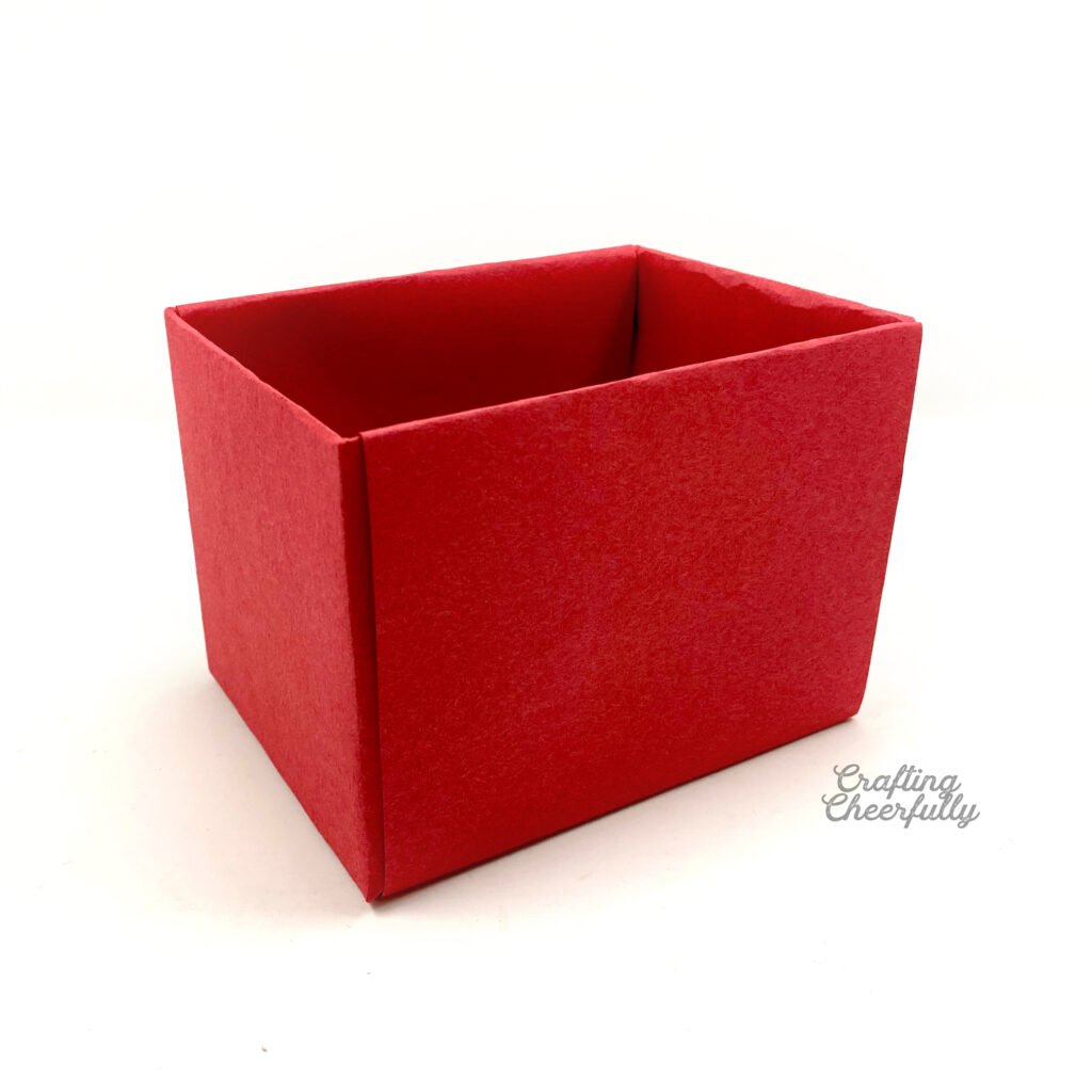 A box covered in red construction paper sits on a white table.