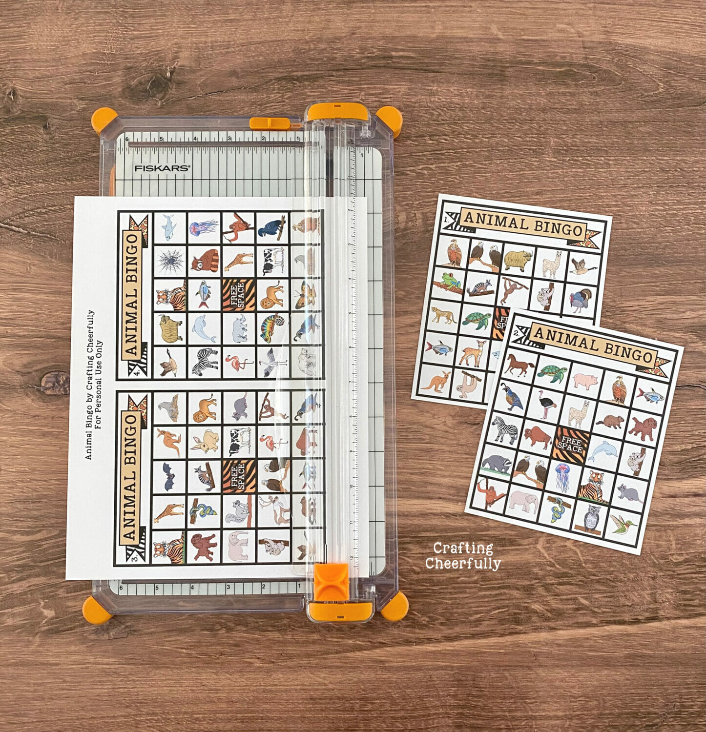 Bingo boards being cut with a paper trimmer on a table.