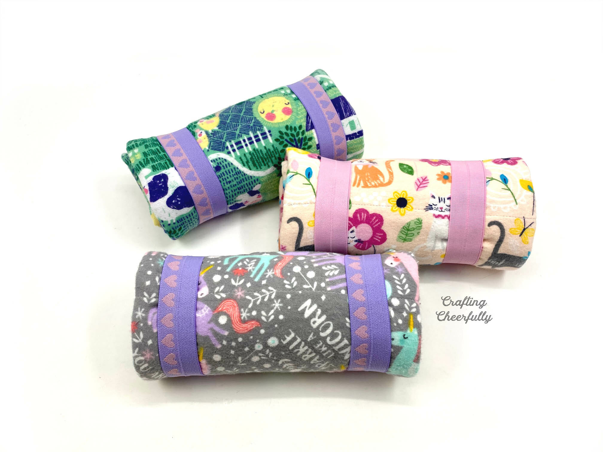 Three rolled up sleeping bags for dolls.