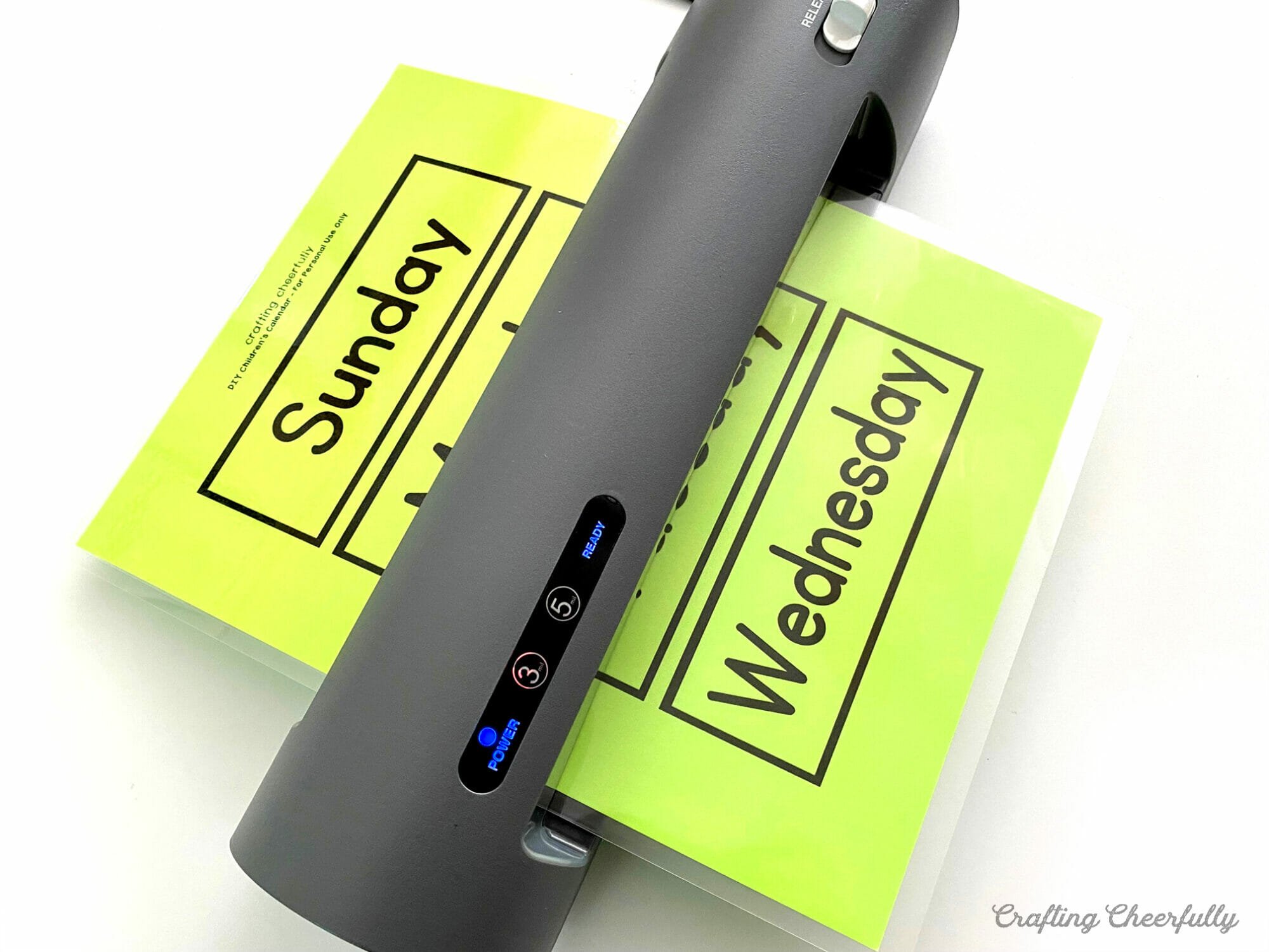 Laminator laminating calendar printable on green paper.