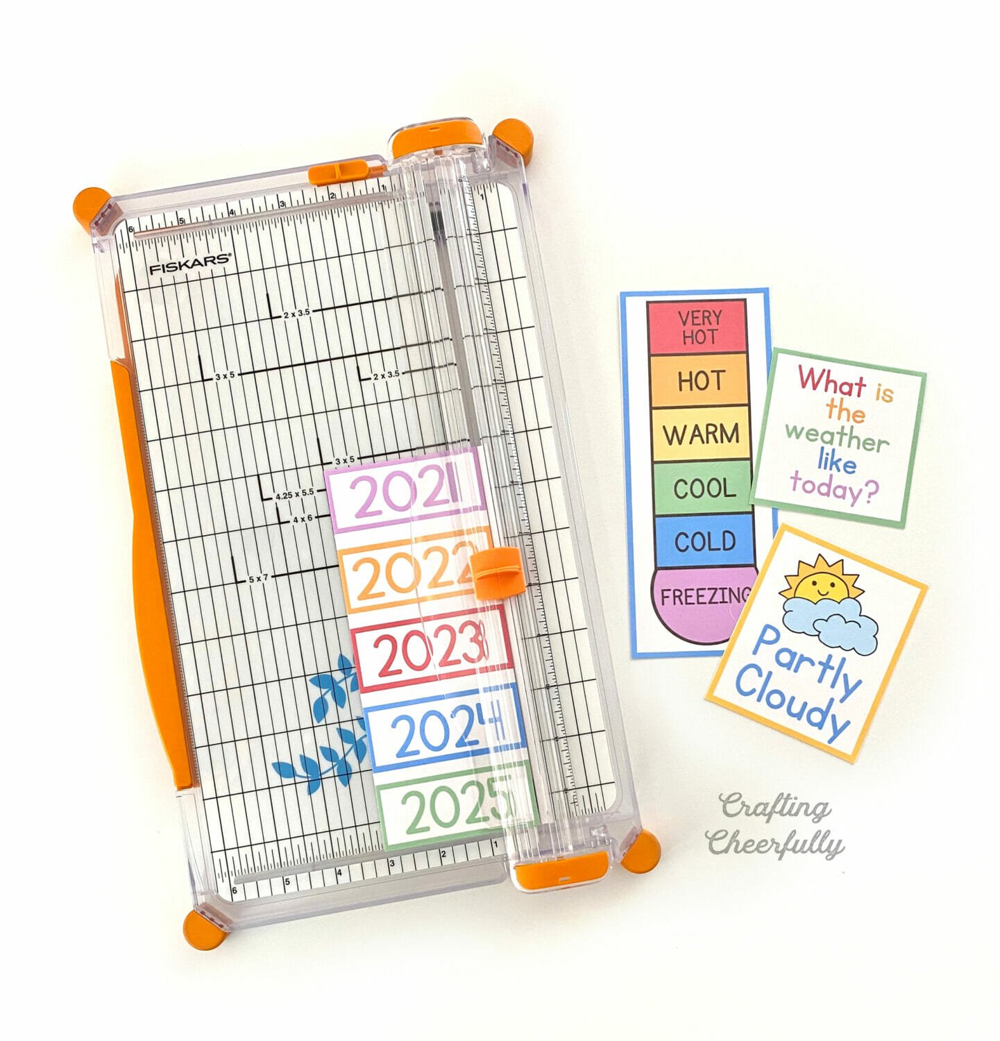 Calendar printables being cut by a paper trimmer.