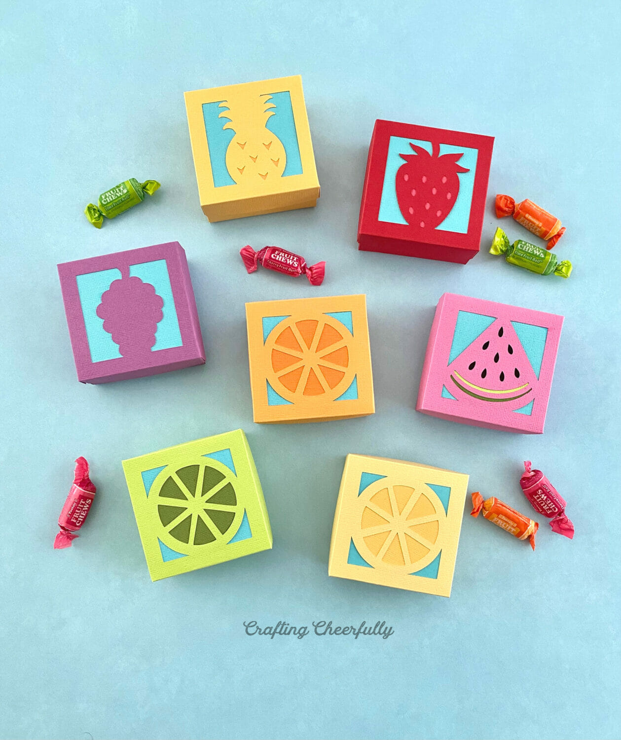 Lots of fruit boxes in a rainbow of colors filled with candy.