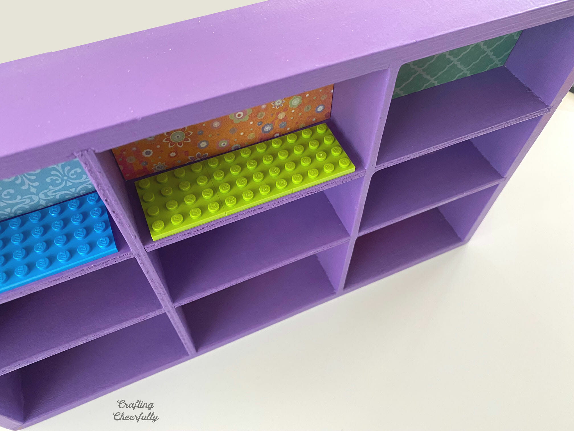 LEGO plates are added to each cubby in the wooden box.