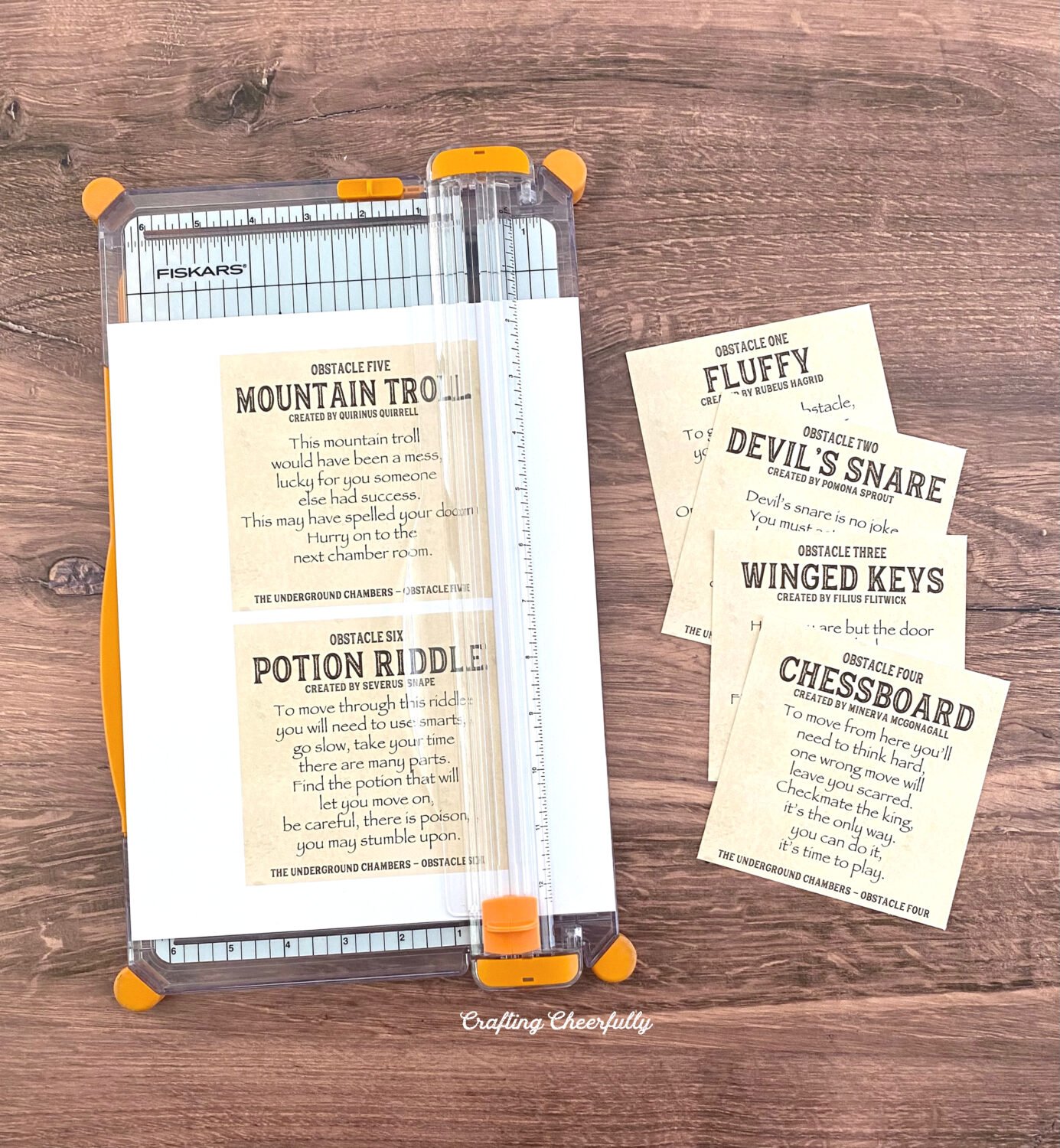Harry potter game cards being cut with a paper trimmer.