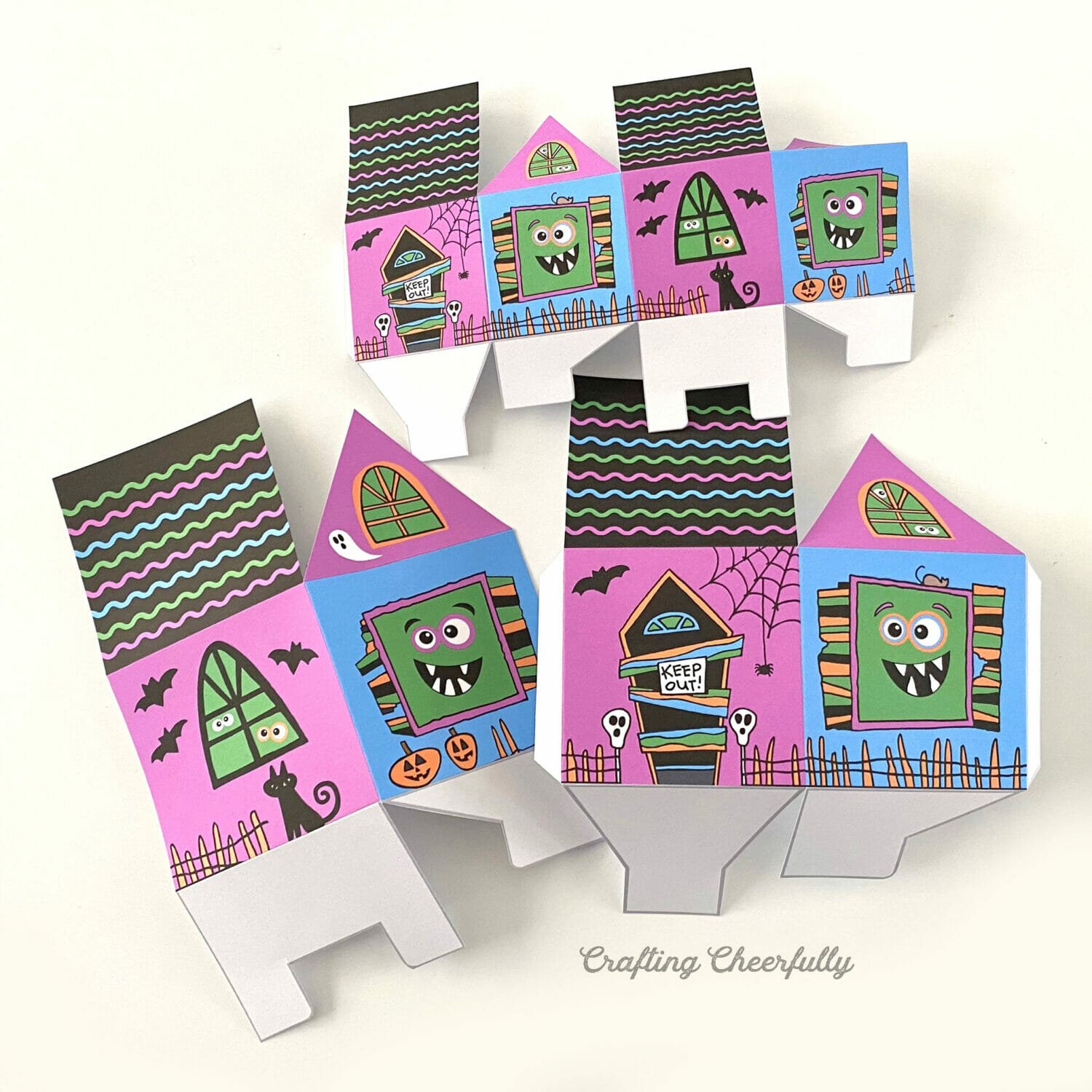 Cut out monster treat box printables folded along their score lines lay on a white table.