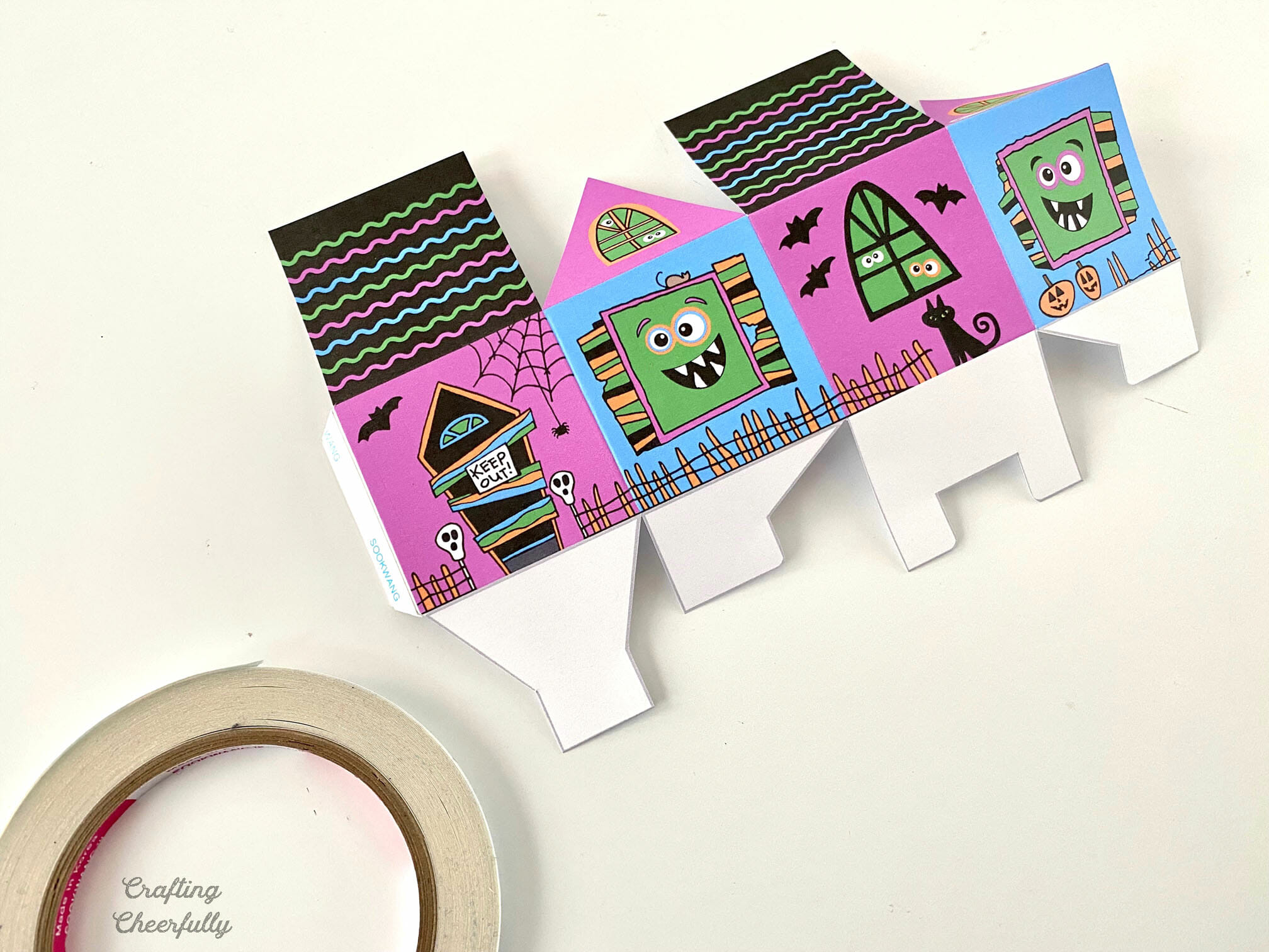 Partially assembled monster haunted house treat box lays on a white table.