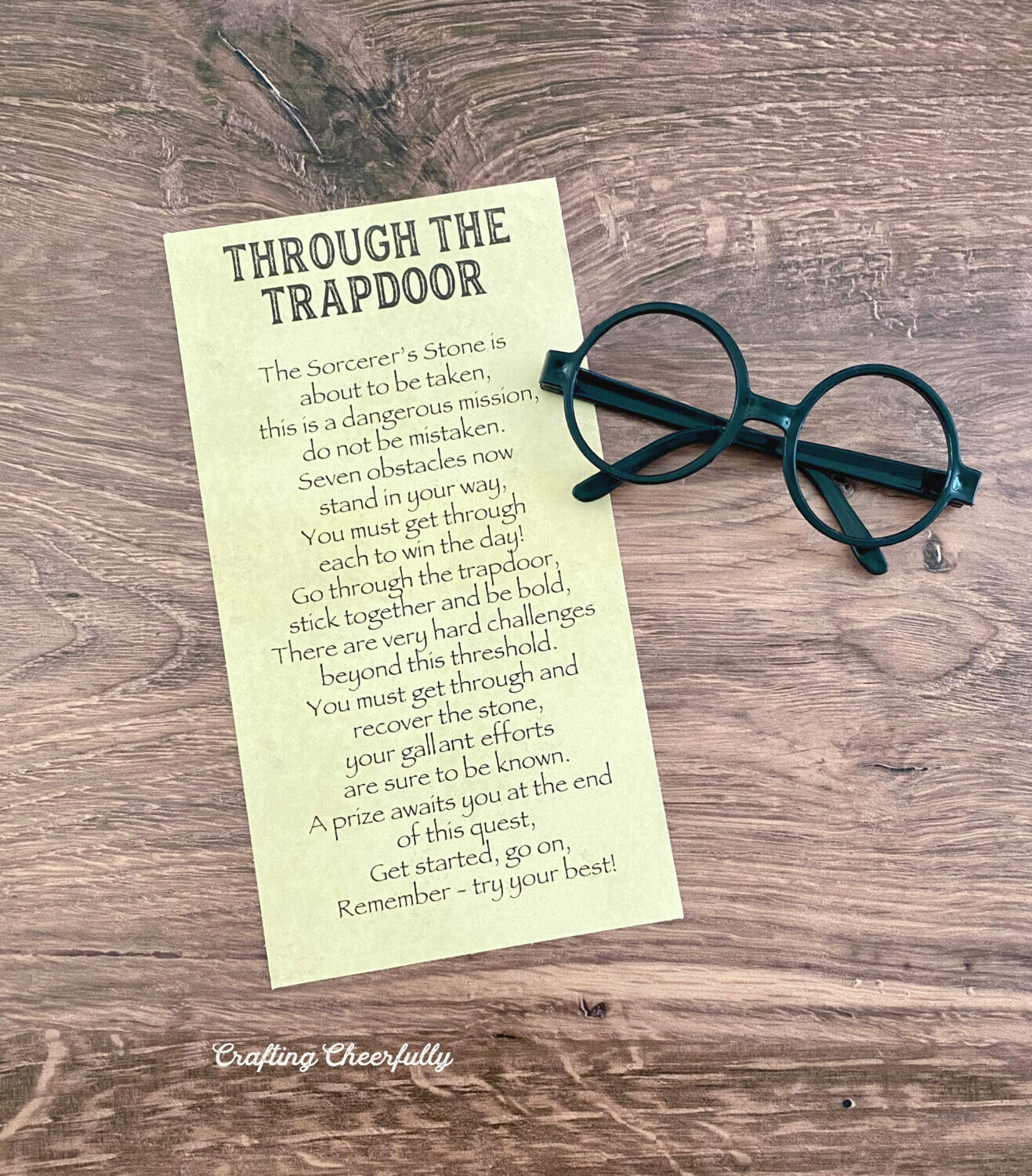First card to the Harry Potter game lays on a table next to a pair of black glasses.