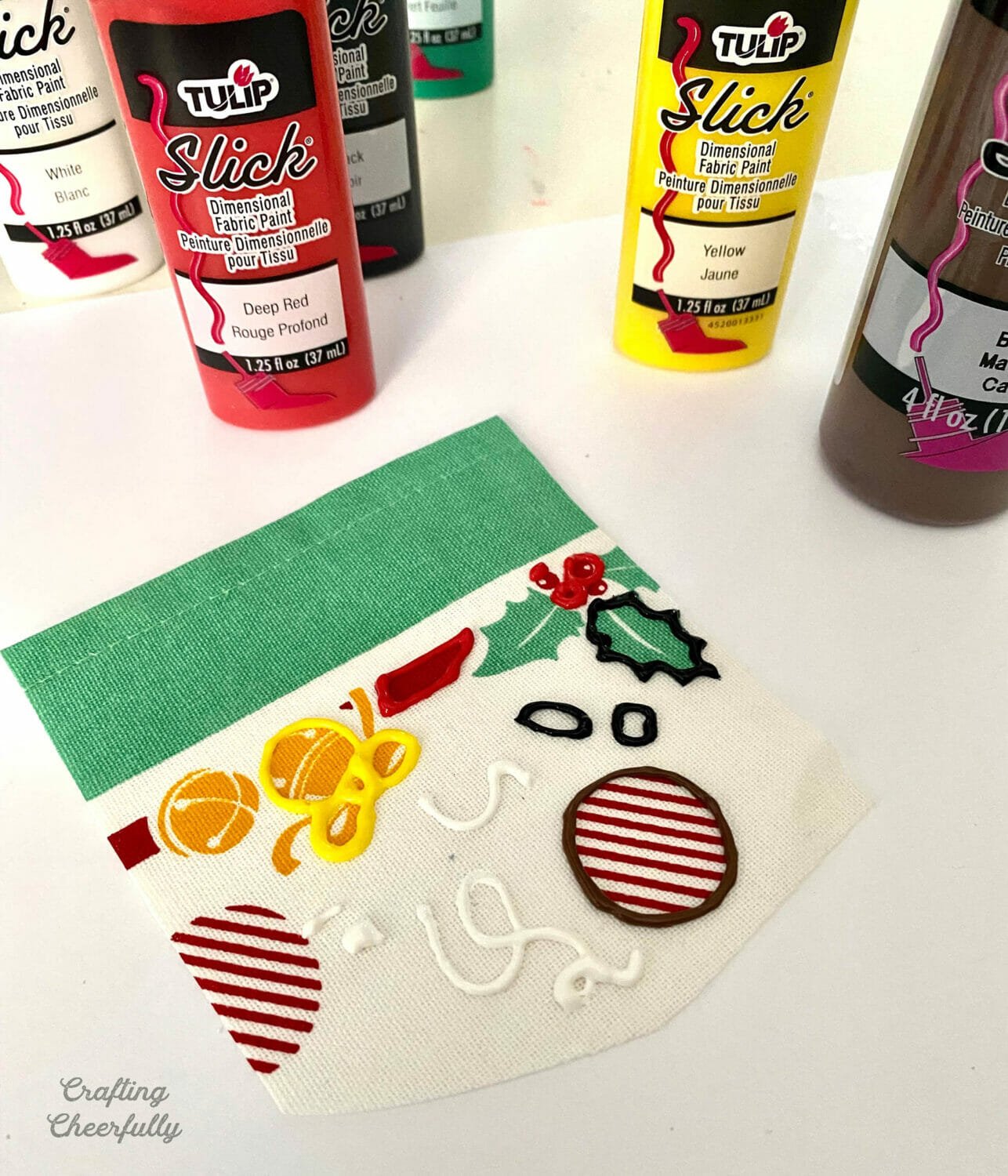 A practice napkin lays on a table with squiggly lines painted in puffy paint.