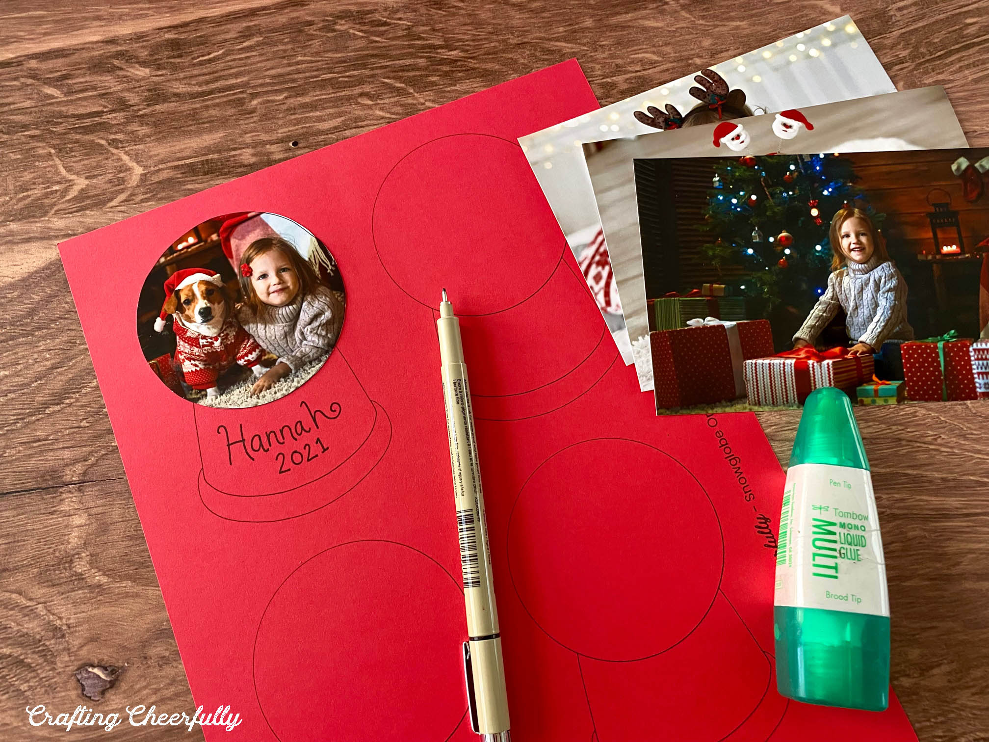 A photo is glued to a snow globe template printed on red paper.