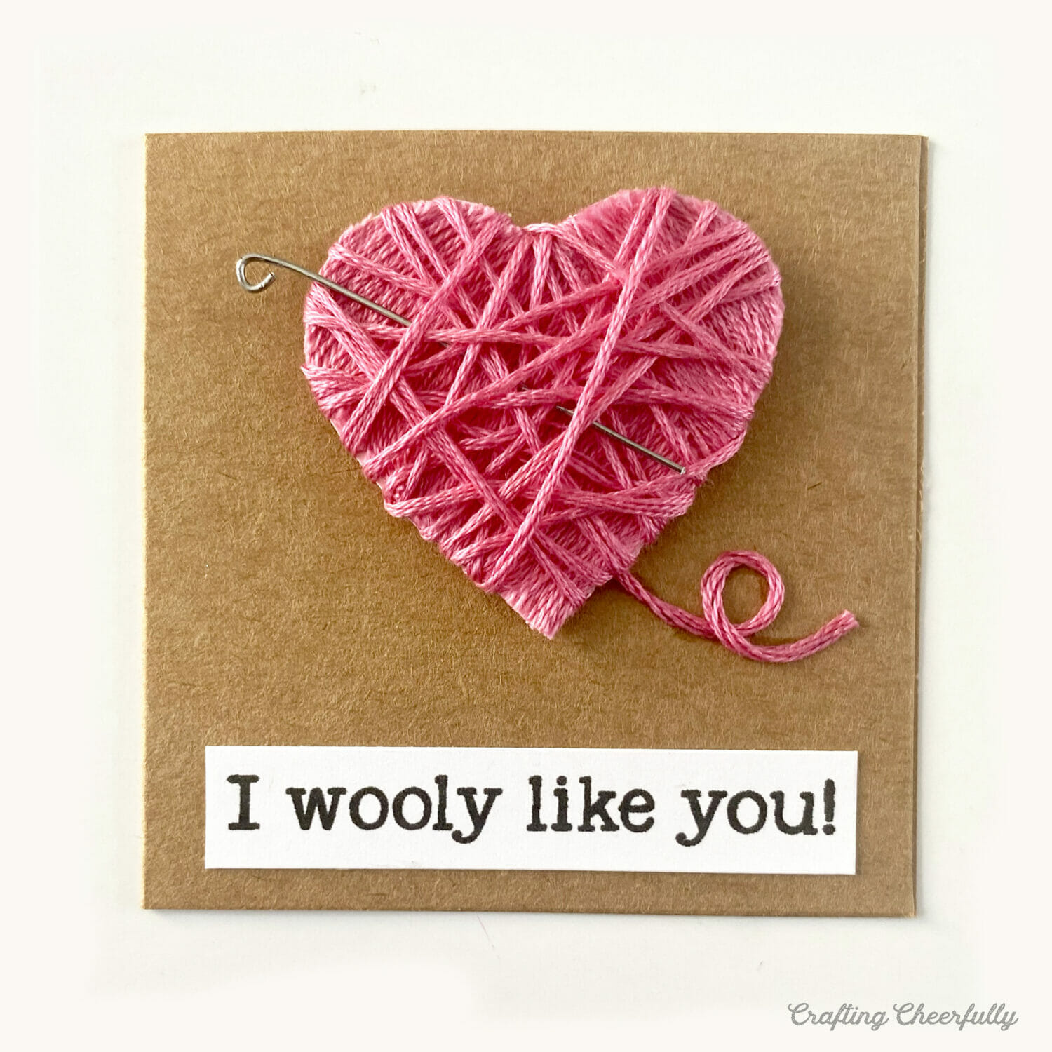 Valentine with a heart wrapped in embroidery thread; it reads I wooly like you.