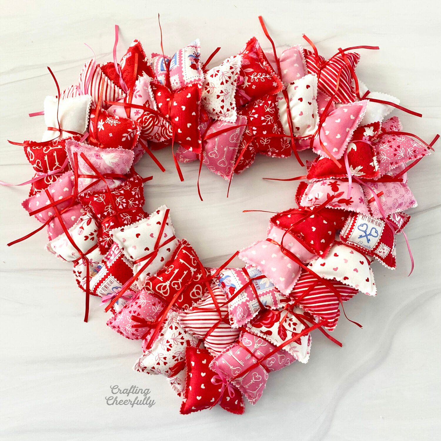 Valentine's Day pillow wreath with the pillows attached but the ribbon not tied into bows.