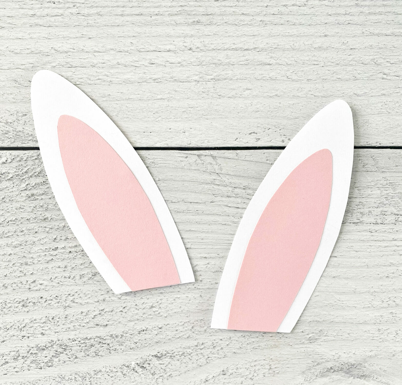 Two bunny ears made from white and pink paper.