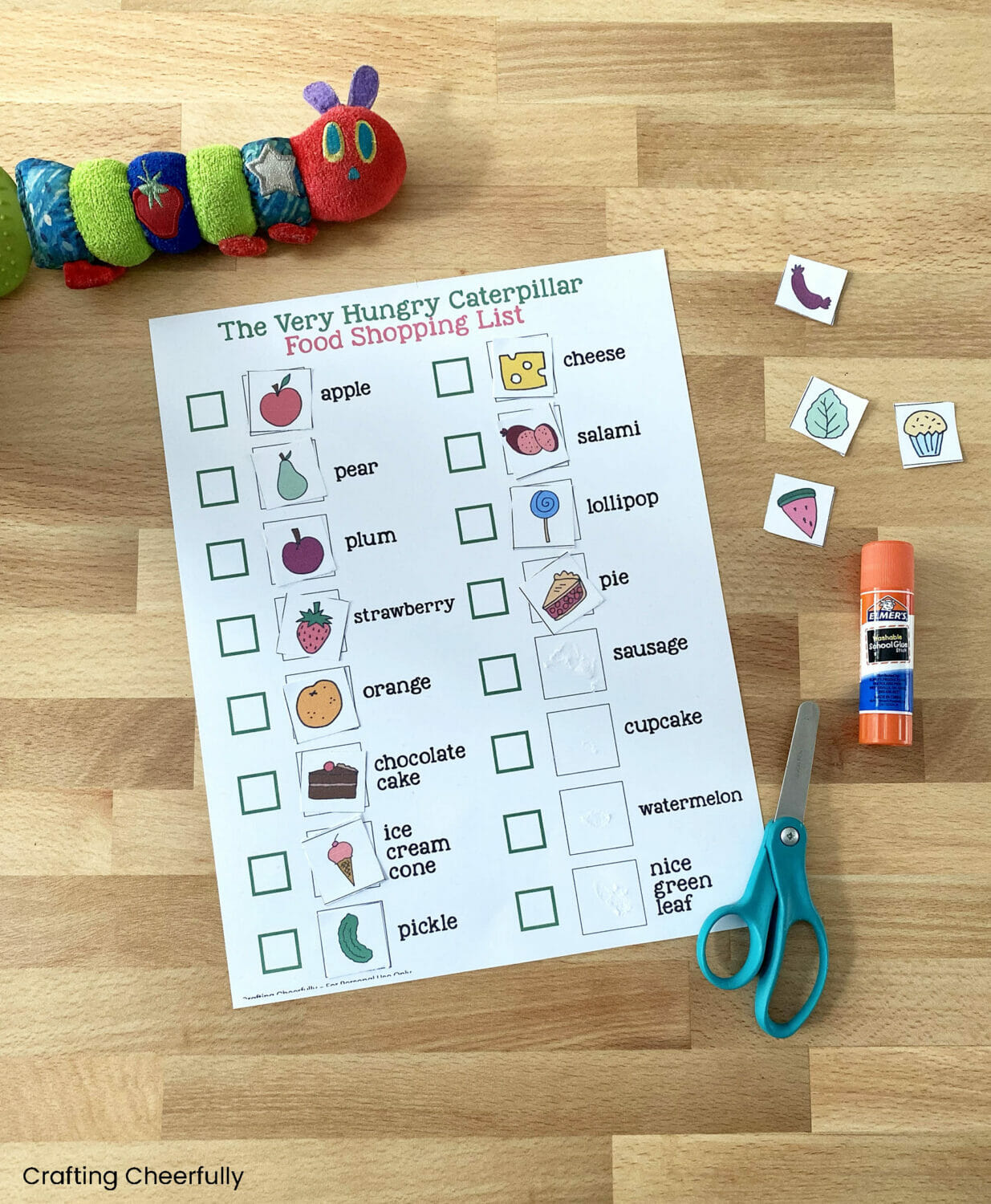Small pieces of paper with pictures of food on them are attached to a large printable shopping list.