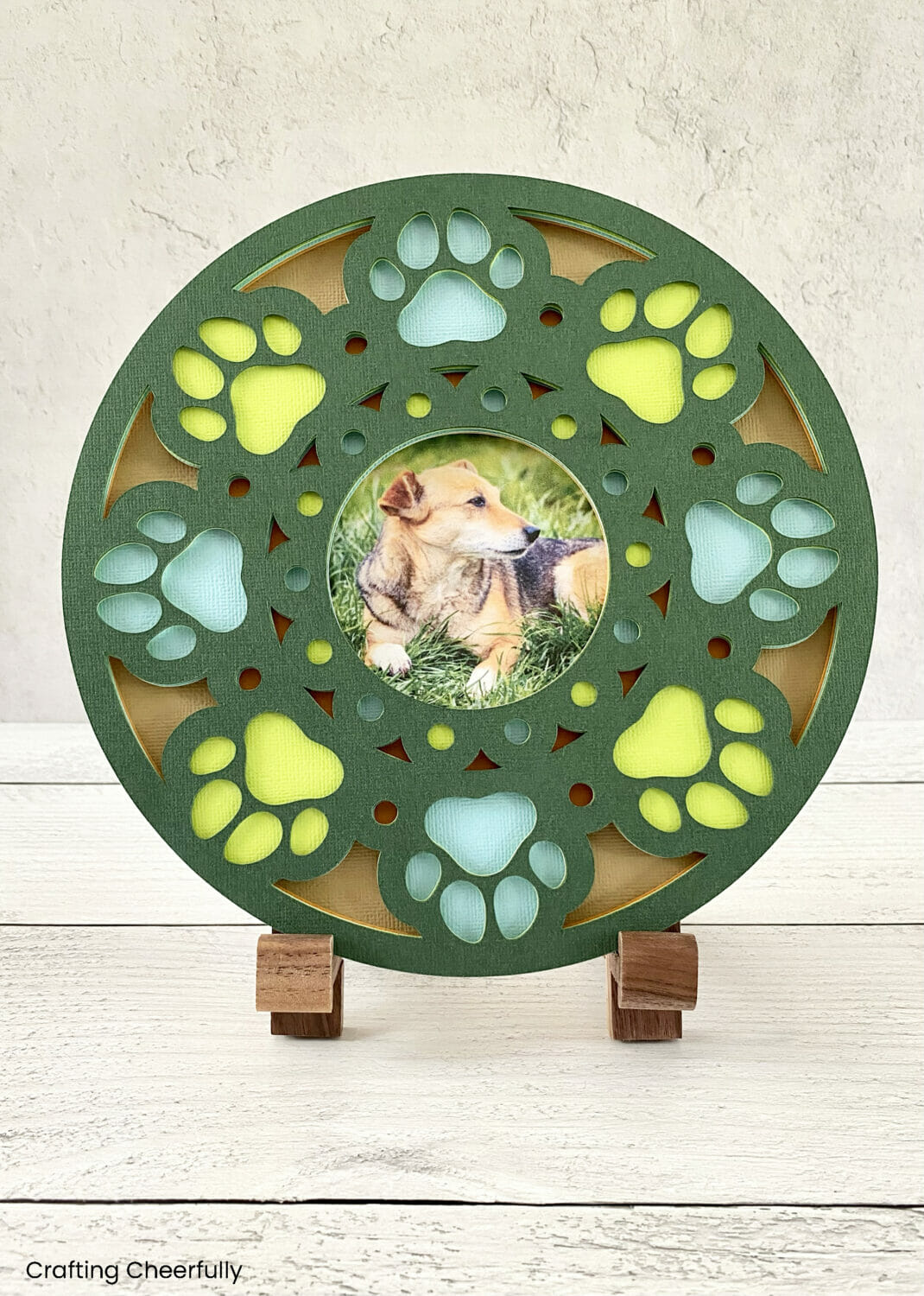 Dog print layered paper frame on a wooden easle.